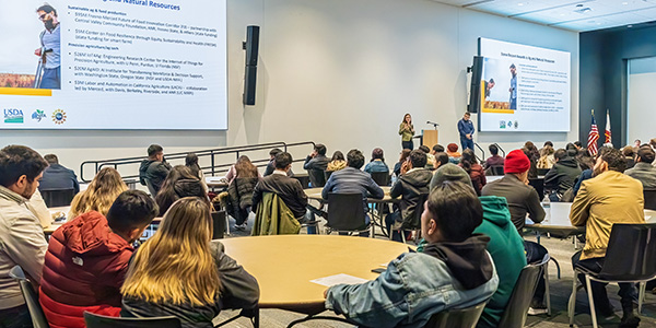 Presenters and students in conference ballroom