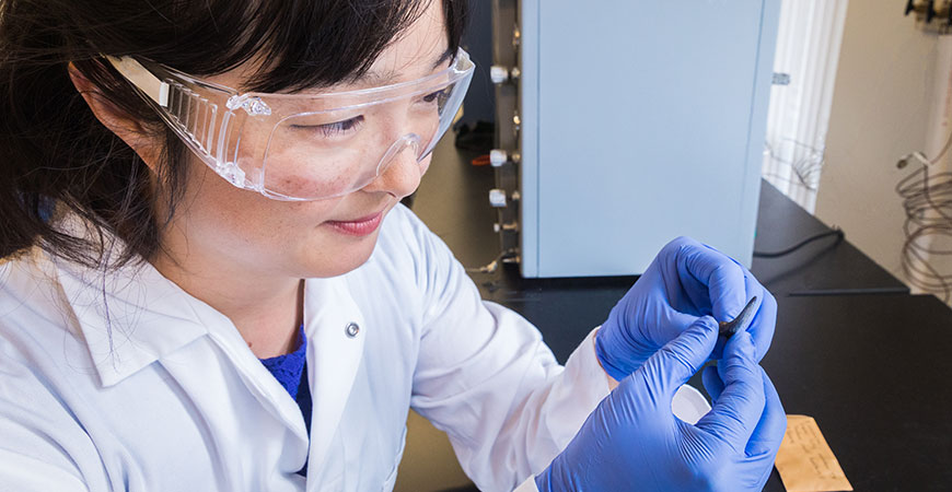 Professor Sora Kim examines a fossilized shark's tooth.