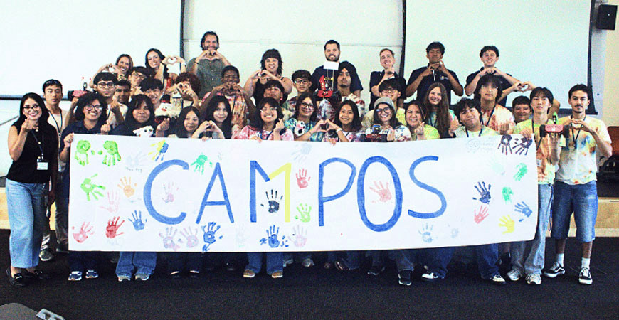 Summer Bridge Academy students pose in front of banner that says Campos